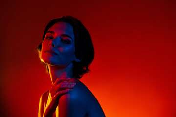 Photo of stunning shiny woman naked shoulders dressed applying body balm empty space isolated red...