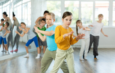 Naklejka premium Dance lesson for young children - girls and boys learn modern dances in pairs