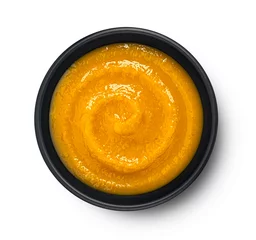 Fotobehang Pumpkin cream soup in black bowl isolated on white background, top view © xamtiw