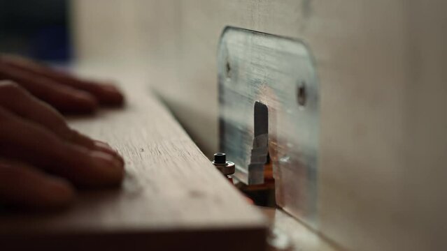 Woodworker operating spindle moulder to create high quality bespoke joinery for customer commissioned project. Machinist at work performing tasks on wood shaper, shaping materials, camera A close up
