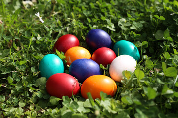 Fototapeta na wymiar Closeup of colorful eggs in beautiful spring meadow on easter holiday outdoors in green graas.Traditional symbol for christian and catholic holiday