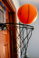 Selective focus on the netting of a miniature toy basketball hoop on the door of a bedroom.  © Lost_in_the_Midwest