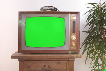 green screen, old retro analog TV 1960-1970, rotary dial telephone, blank screen for designer, background, stylish mockup, template for video - obrazy, fototapety, plakaty