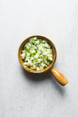 Overhead view of diced cucumber in a brown ramekin, Diced cucumber for a salad bowl or meal prep