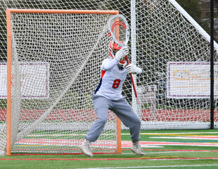 Girls lacrosse goalie guarding the goal during a game