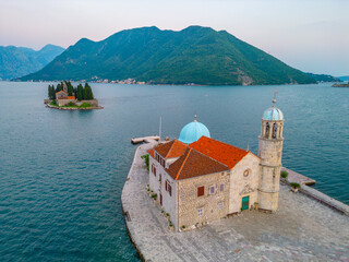 Sunset aerial view of Church of Our Lady of Skrpjela and Saint George Catholic Monastery near...