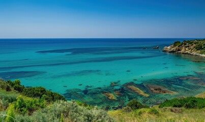 This stunning image captures the serene beauty of a coastal landscape with vivid turquoise waters meeting a lush green shoreline