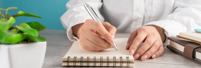 Woman making notes in notepad, business concept