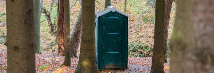 Green toilet cabin in the forest