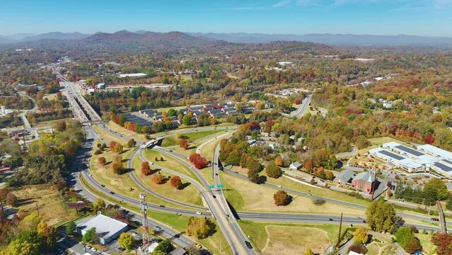 American freeway intersection in Asheville, North Carolina with fast driving cars and trucks in autumnal season. View from above of USA transportation infrastructure