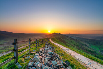 Stone footpath and wooden fence leading a long The Great Ridge in the English Peak District - 779279485