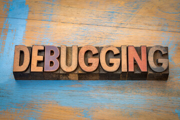 debugging  - word abstract in vintage letterpress wood type against grunge wood, computer software concept