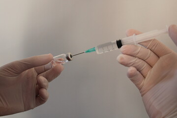 a person is holding a syringe with a green liquid.