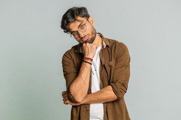 Indian young man tired bored indifferent expression, exhausted of tedious story, not interested in communication talk, displeasure, uninteresting. Arabian guy isolated on gray background indoors - obrazy, fototapety, plakaty