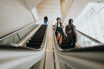 Professional business people on escalator in modern office building.