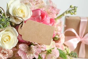 Happy Mother's Day. Beautiful flowers with blank card on light background, closeup