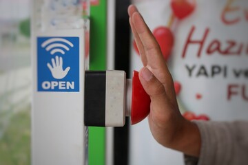 A male hand pressing a red button. fire and emergency notification. button to open the bus stop door.