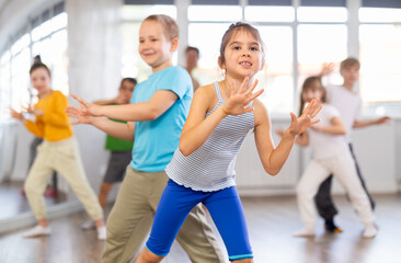 Fototapeta na wymiar Dance lesson for young children - girls and boys learn modern dances in pairs