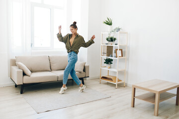 Fototapeta na wymiar Playful Joy: A Happy Woman Jumping and Dancing in her Home Interior