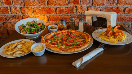 Delicious Italian meal spread with pizza, pasta, and salad