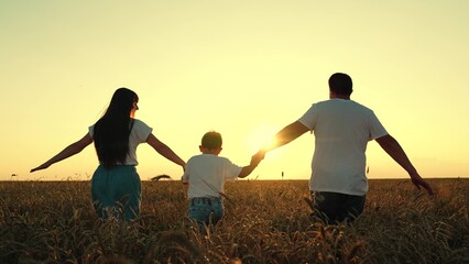 Father Mother son enjoying nature together on yellow wheat field. Happy family of farmers with...