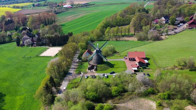 Aerial drone view of ancient windmill with agricultural fields in background in German countryside. High quality 4k footage