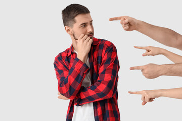 People pointing at young man on white background. Accusation concept