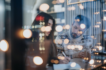 Focused young adults engaged in a project late at night, surrounded by warm ambient cafe lights. A feeling of dedication and collaboration.