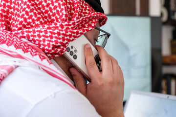 arabic male using phone during work to make sure it is flow is in the right direction - obrazy, fototapety, plakaty