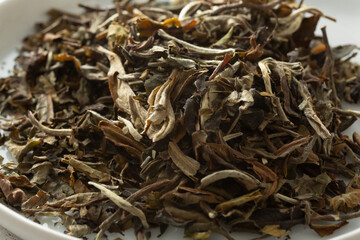 A closeup view of a pile of loose leaf pai mu tan white tea.