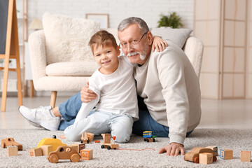 Grandfather playing with his cute little grandson at home