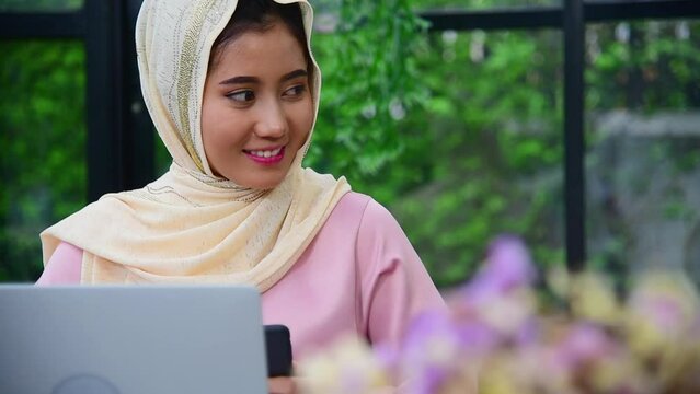 Smiling Muslim woman wear hijab use digital tablet surf internet work at home office. Portrait Happy smile face Muslim woman wear hijab touch smart tablet. Muslim empower women video call conference
