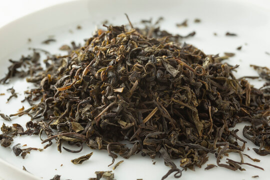 A closeup view of a pile of loose leaf bi luo chun green tea.