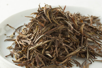 A closeup view of a pile of loose leaf huoshan huangya yellow tea.