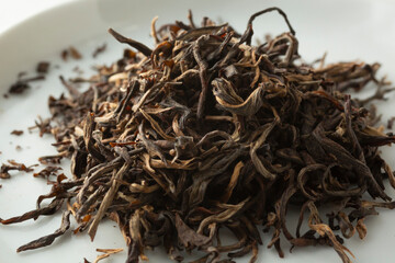 A closeup view of a pile of loose leaf huoshan huangya yellow tea.
