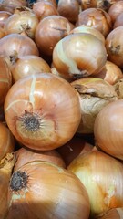 Close up pile of fresh onions placed together in local market as a background.	
