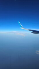 Looking through window aircraft during flight in wing with a nice blue sky clouds.