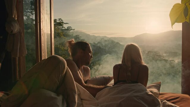 Lovers lying in bed with an amazing view and drinking tea