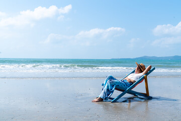 Happy Asian woman relax and enjoy outdoor lifestyle travel nature ocean on summer holiday vacation. Attractive girl sleeping on sunbed at tropical island beach in sunny day. People and nature concept.