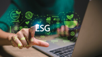A person is pointing at a laptop screen with the word ESG on it - obrazy, fototapety, plakaty