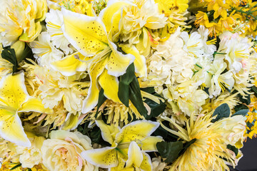 Artificial yellow lilies and roses