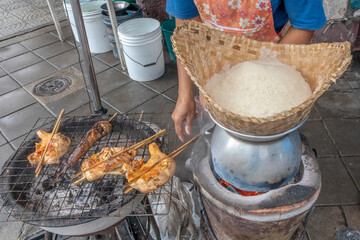 Barbecued chicken with rice steamed in a wicker basket - obrazy, fototapety, plakaty