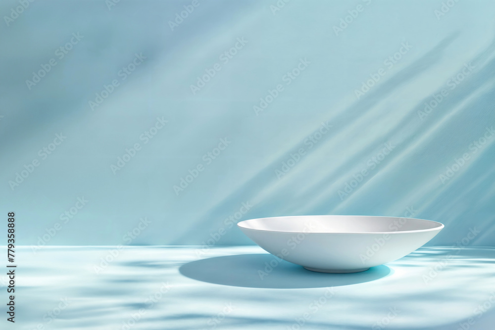 Poster White empty bowl on blue background with natural light and shadows. Minimalistic design with space for text. High quality photo