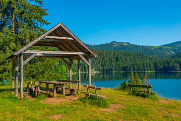 Fototapeta na wymiar Wooden bench at the Crno Jezero aka Black lake at Durmitor national park in Montenegro