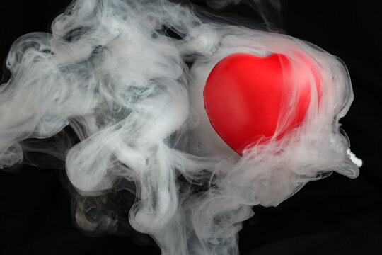 Red love hart flowing flying though white fog smoke mist on black background