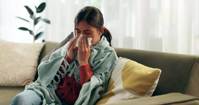 Woman, sick and blowing nose on couch for flu illness or sneezing disease with blanket, allergy or virus. Female person, tissue and sofa in home for bacteria problem in lounge, sinus or influenza