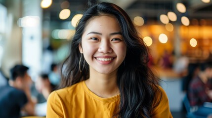 A young asian professional woman sitting in a restaurant smiling confidently at the camera