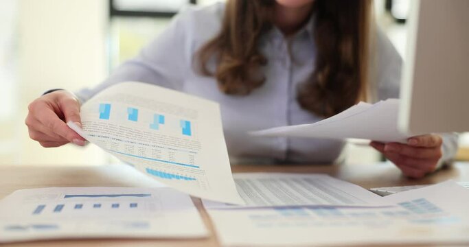 Businesswoman looking through financial documents at workplace