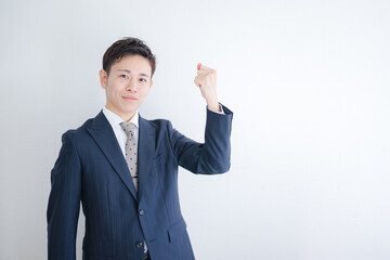 拳を掲げる若いスーツ男性