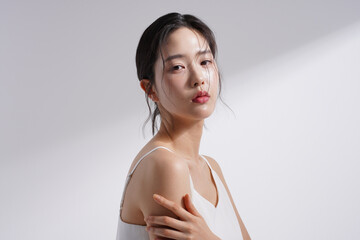 光と影の背景で撮影をした若い韓国人女性の美容イメージ